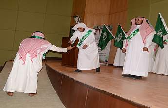 مدير الجامعة يرفع عقال أحد الطلاب المشاركين في احتفالية اليوم الوطني